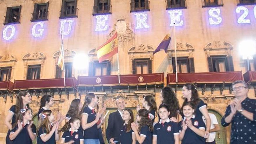 Alicante estrenó anoche su iluminación de Hogueras. La Bellea y sus damas inauguraron el encendido en la plaza del Ayuntamiento y recorrieron el centro bajo las luces.