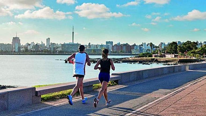 Una pareja corre por el paseo marítimo de Montevideo.