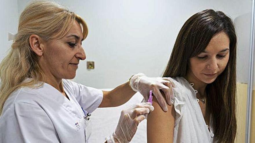 Una joven recibe la vacuna contra la gripe durante la primera jornada de campaña en la capital.