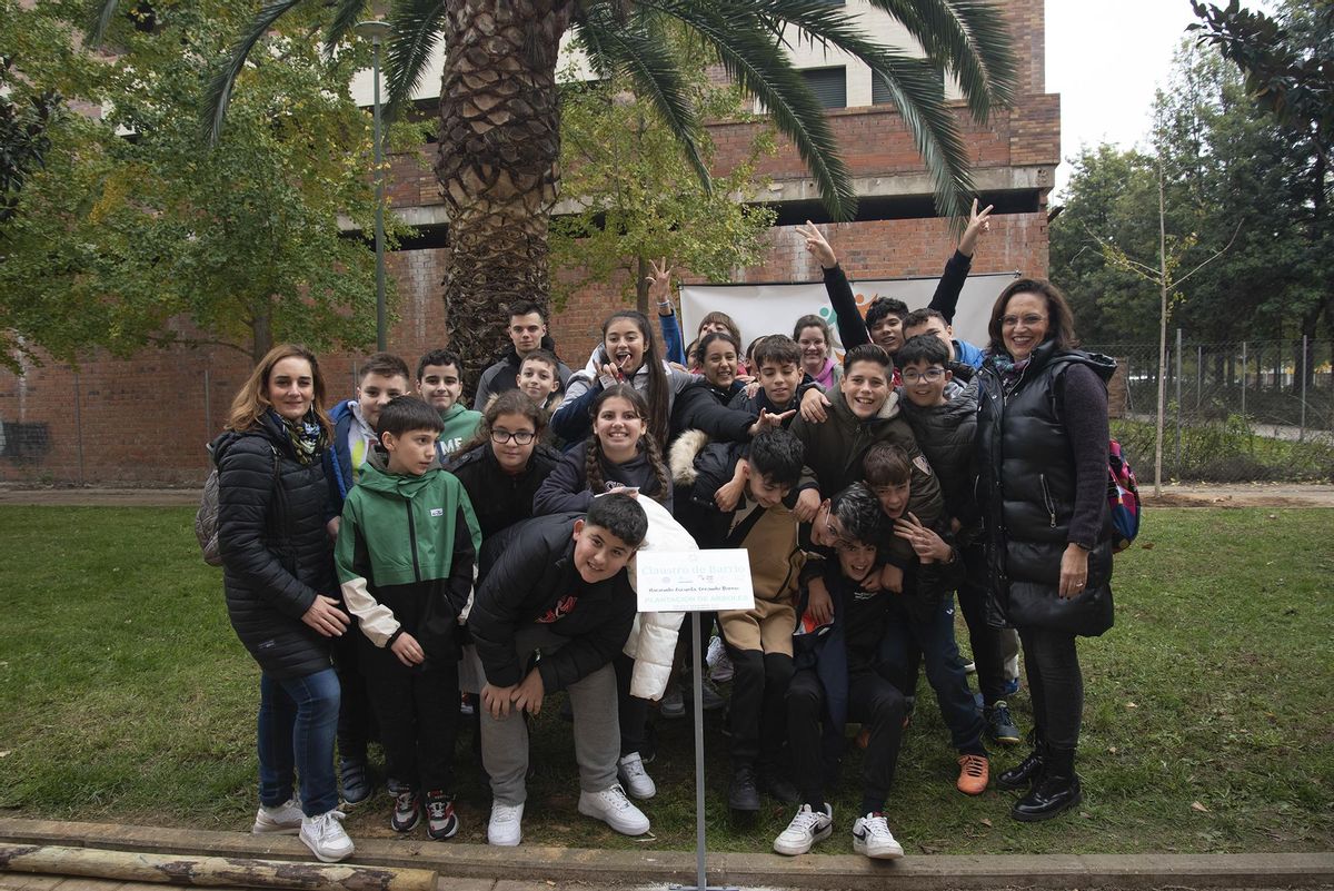 Un grupo de escolares y sus profesoras junto a la placa conmemorativa.