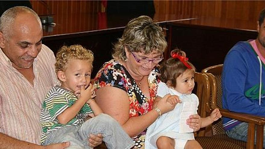 Los padres, Abdel Kader y Blanca Llorca, con los pequeños Ismael y Fátima, mientras el padrino les sonríe.