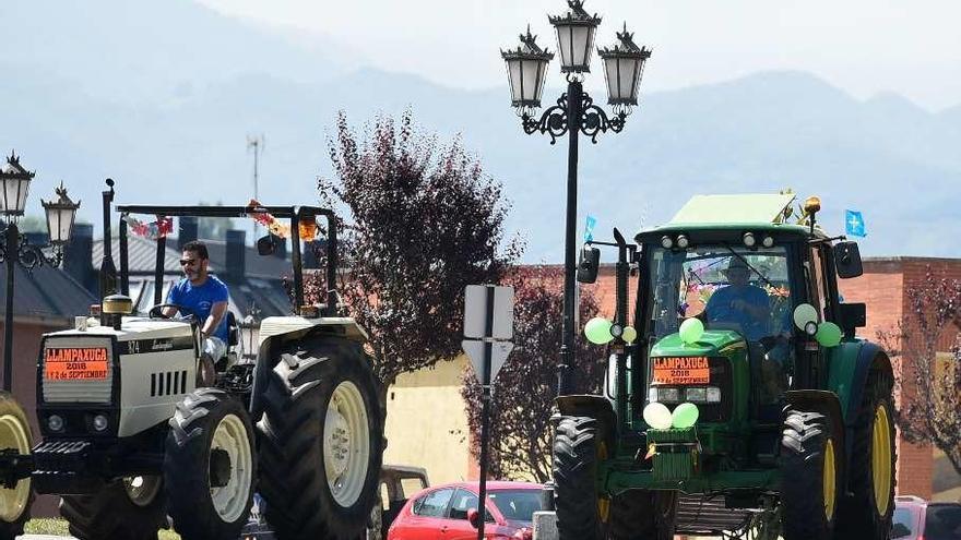 Los vecinos de Llampaxuga se van de fiesta subidos en tractor