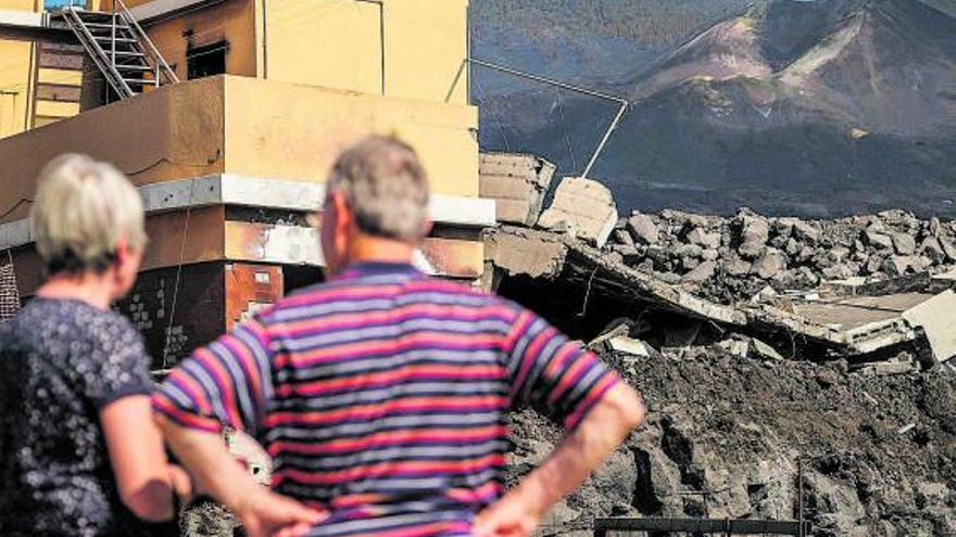 Vecinos de La Laguna (Los Llanos de Aridane) contemplan el volcán y los destrozos provocados por la colada. | | ANDRÉS GUTIÉRREZ