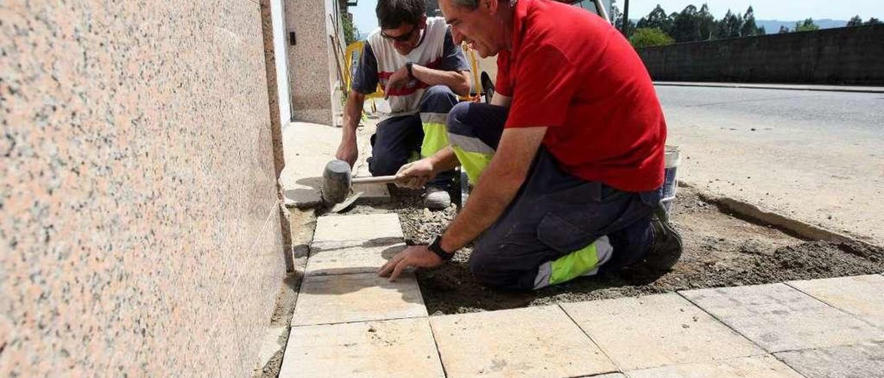 Operarios del Concello de A Estrada, ayer, restaurando la acera de Fernando Conde. // Bernabé / Cris M.V.