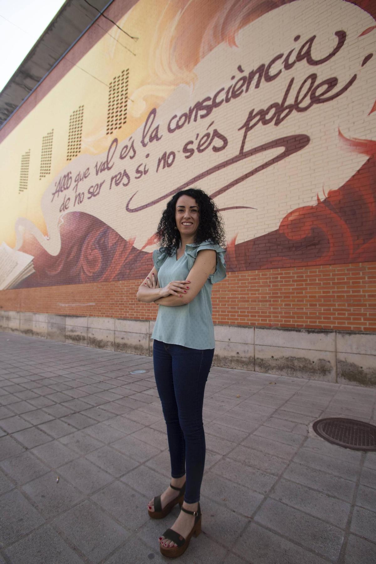 La alcaldesa de Tavernes de la Valldigna, ante el mural de homenaje a Vicent Andrés Estellés.