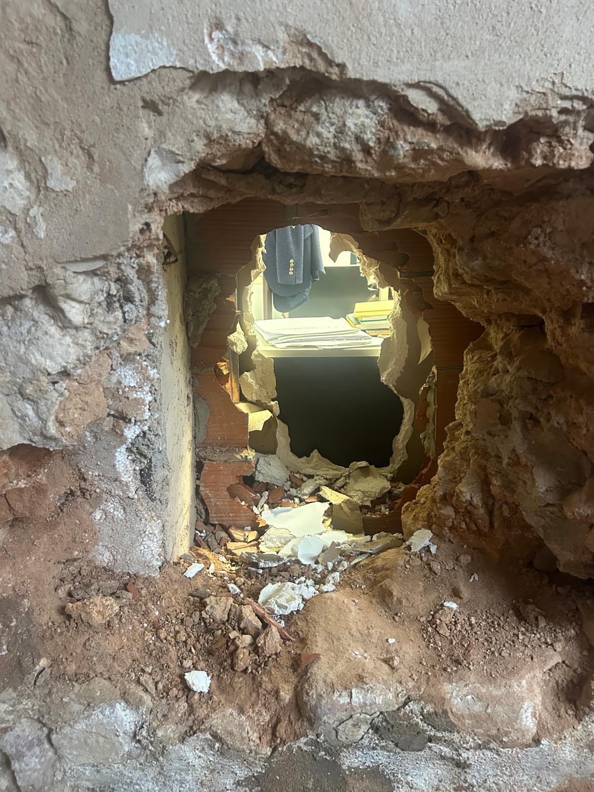 Imagen del butrón realizado desde el interior de una vivienda deshabitada.