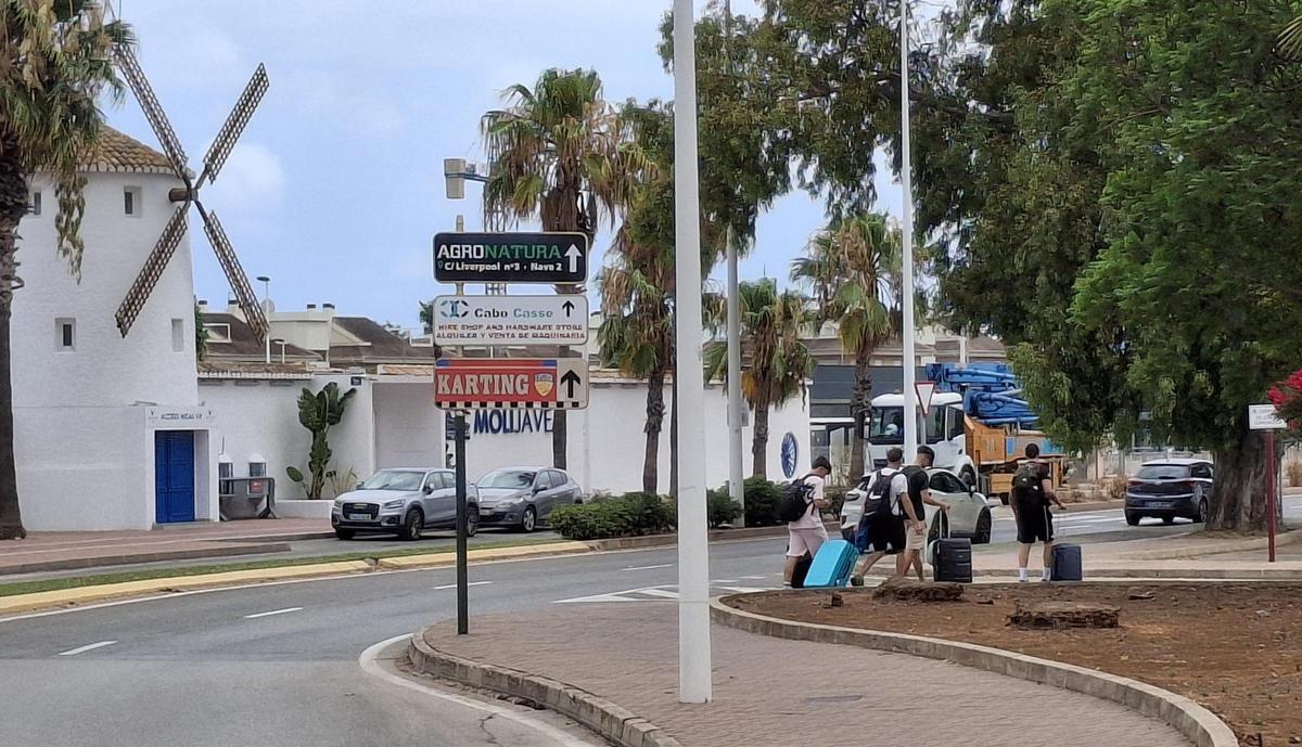 Un grupo de amigos con la maleta a rastras busca su apartamento de alquiler turístico