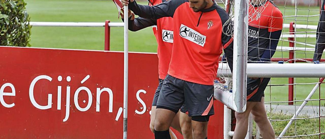 Por la izquierda, Borja López, Bogdan y Mateo colocan un banderín en el campo número 2 de Mareo durante el entrenamiento de ayer. | Á. González