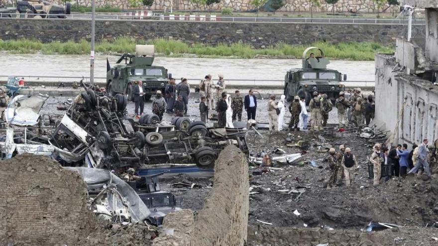 Agentes de seguridad inspeccionan el escenario del atentado de Kabul, con el camión bomba a la izquierda.
