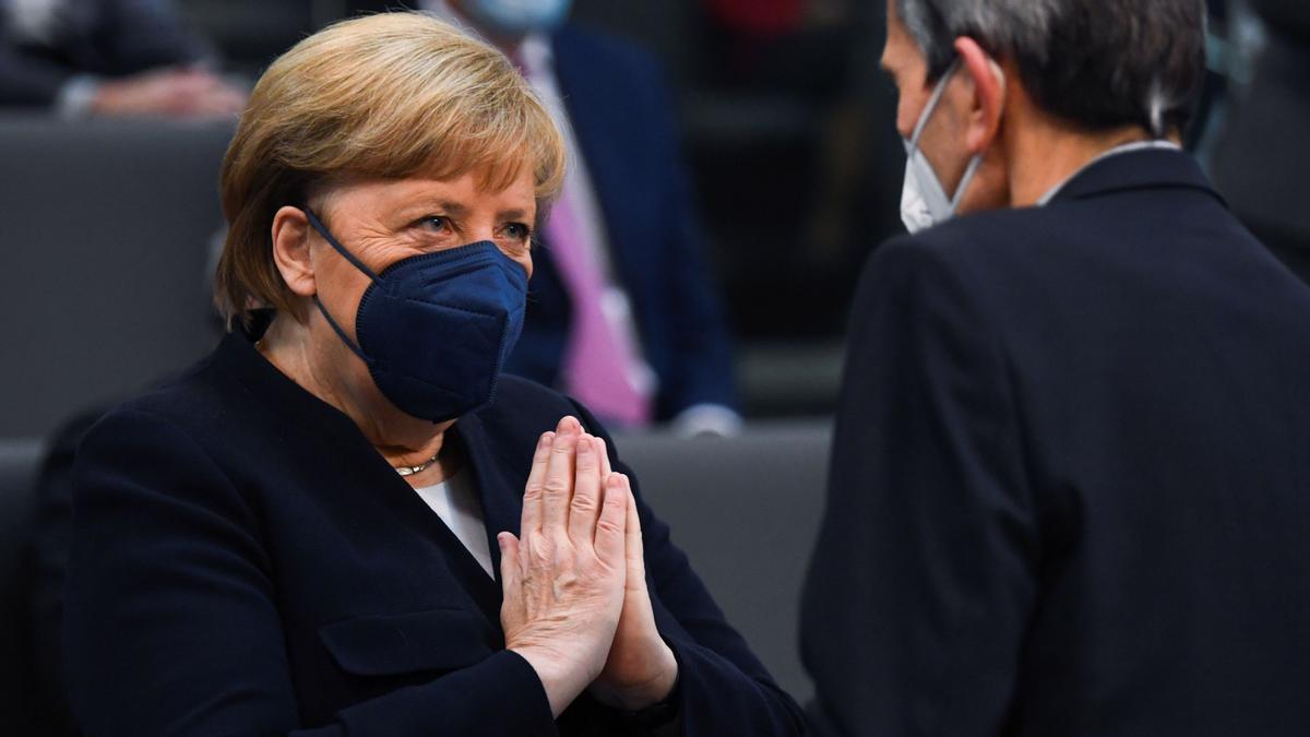 Angela Merkel en un gesto de agradecimiento al líder del grupo parlamentario SPD, Rolf Muetzenich