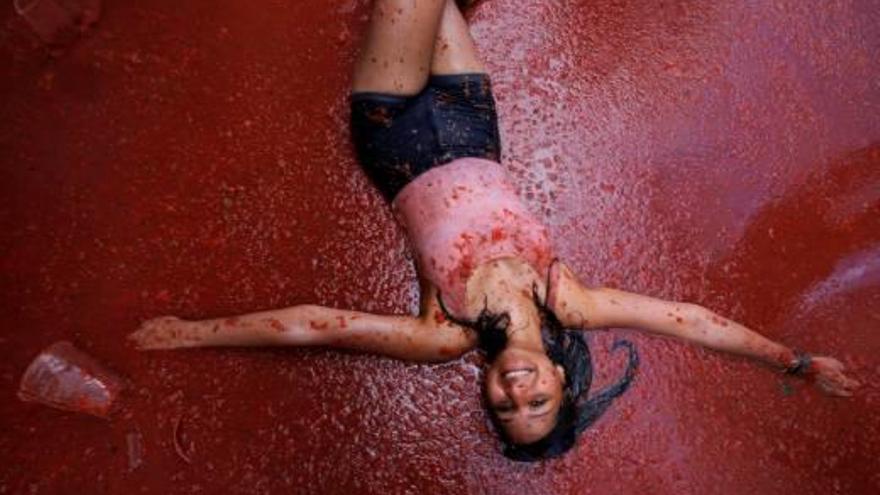 Una noia juga amb la polpa de tomàquet a La Tomatina de Bunyol