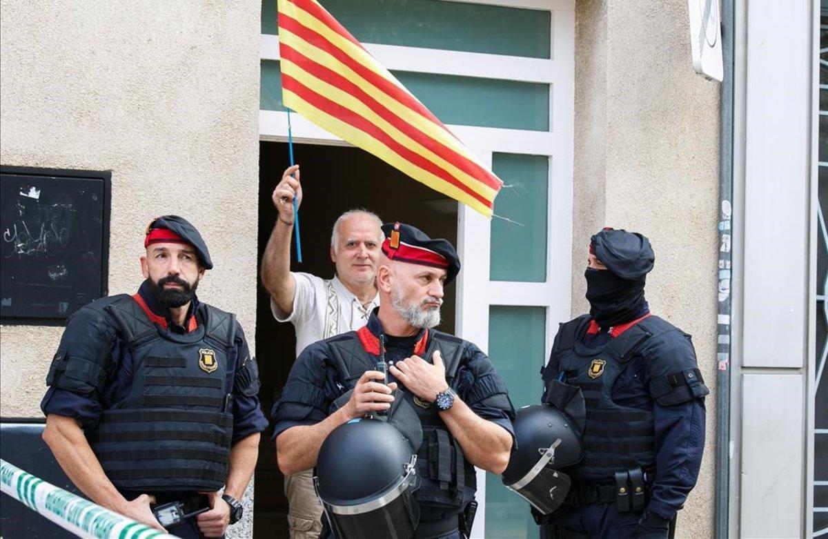 Un hombre con una ’senyera’, junto a unos agentes en la operación contra los CDR en Sabadell.