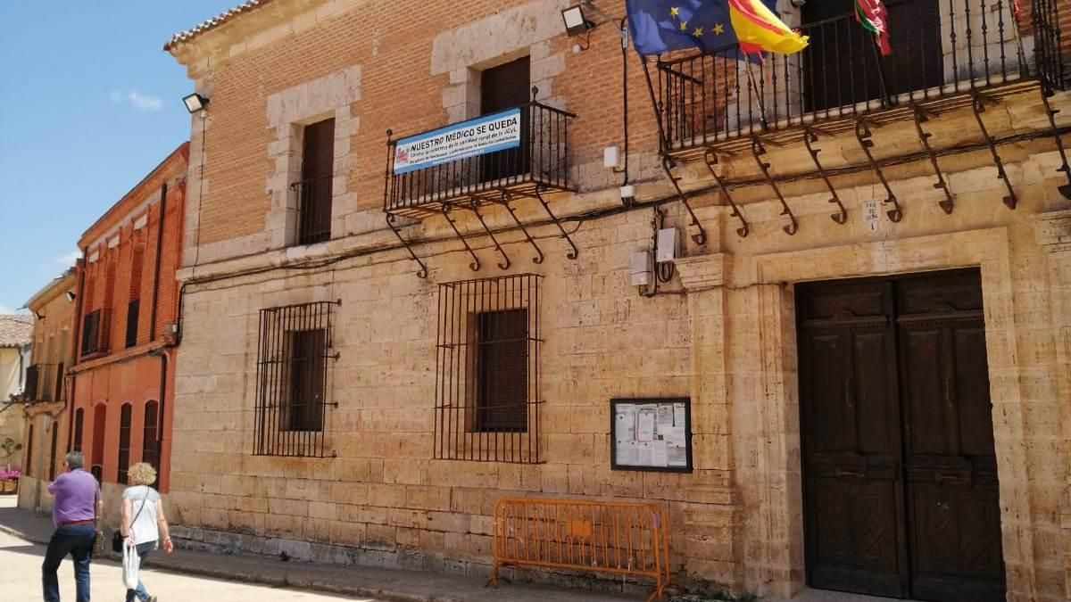 Dos vecinos pasean por la plaza en la que está enclavado el Ayuntamiento de Morales de Toro