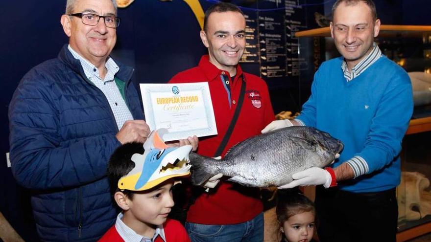 El pescador Gerardo Martínez, en el centro, posa con la chopa y el diploma del récord en presencia de sus dos hijos, Iker y Antía Martínez Castañeda, arropado por Constancio Herrera, a la izquierda, y José Luis Menéndez.