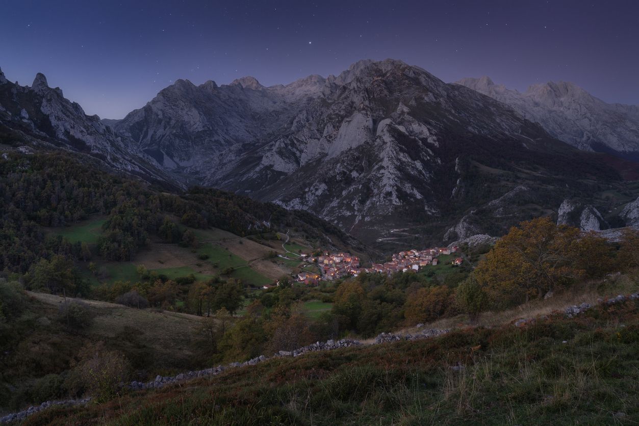 Pueblo de Sotres antes de la puesta de sol con estrellas en el cielo