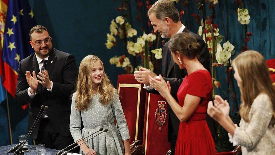 La princesa Leonor es felicitada por su padre, el Rey Felipe, tras pronunciar su primer discurso en público en la ceremonia de entrega de los Premios Princesa de Asturias 2019 en el Campoamor, mientras su madre, la Reina Letizia, y su hermana, la infanta Sofía, aplauden.