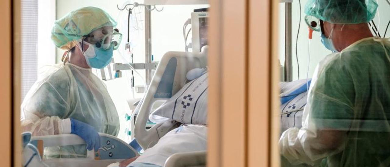 Dos sanitarios atienden a un paciente afectado por el Covid-19 en la UMI del Hospital Universitario Insular de Gran Canaria. | | EFE/ÁNGEL MEDINA