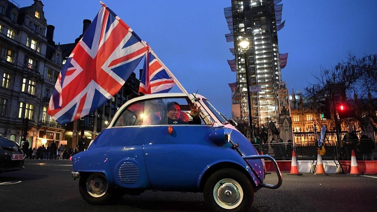 Un hombre ondea una bandera desde un coche por el centro de Londres, este viernes.