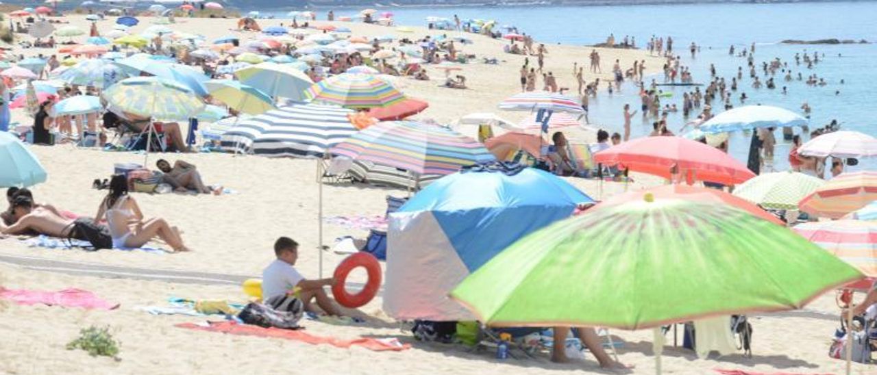 Bañistas, ayer, en la playa de Portomaior de Bueu, disfrutando del primer sábado de julio. | GONZALO NÚÑEZ