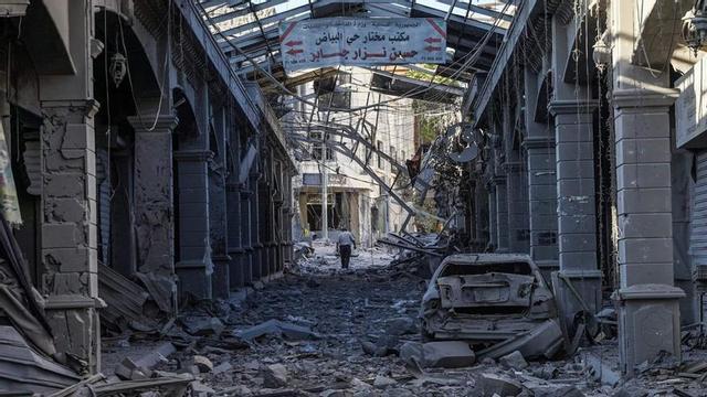 Un home camina enmig de la runa per un carrer destruït a la ciutat de Nabatieh. | ABBAS FAKIH / AFP