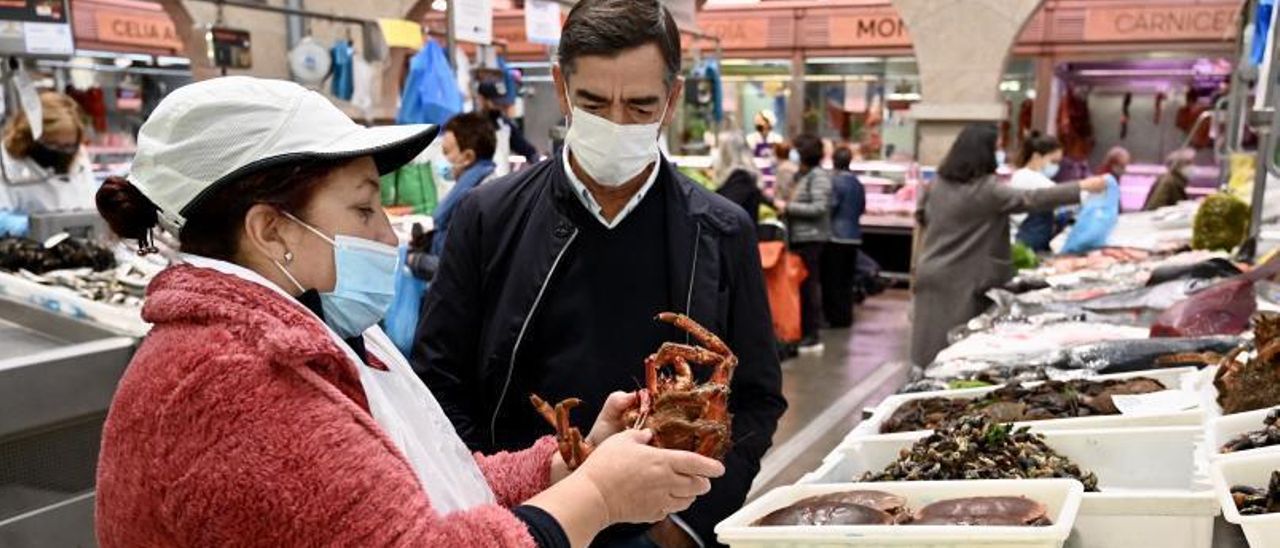 Una placera muestra una centolla a un cliente en el Mercado de Pontevedra. // RAFA VÁZQUEZ