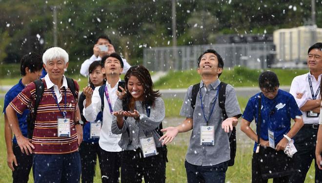 Funcionarios del Comité Olímpico de Tokio 2020 reaccionan mientras se genera nieve artificial cerca de las gradas durante el evento Ready Steady Tokyo canoe sprint, evento de prueba antes de los Juegos Olímpicos de Tokio 2020, en Tokio.