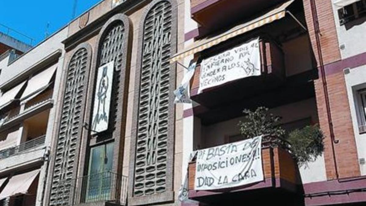 La parroquia donde se ubicará el nuevo centro junto a un edificio con pancartas de protesta, ayer.