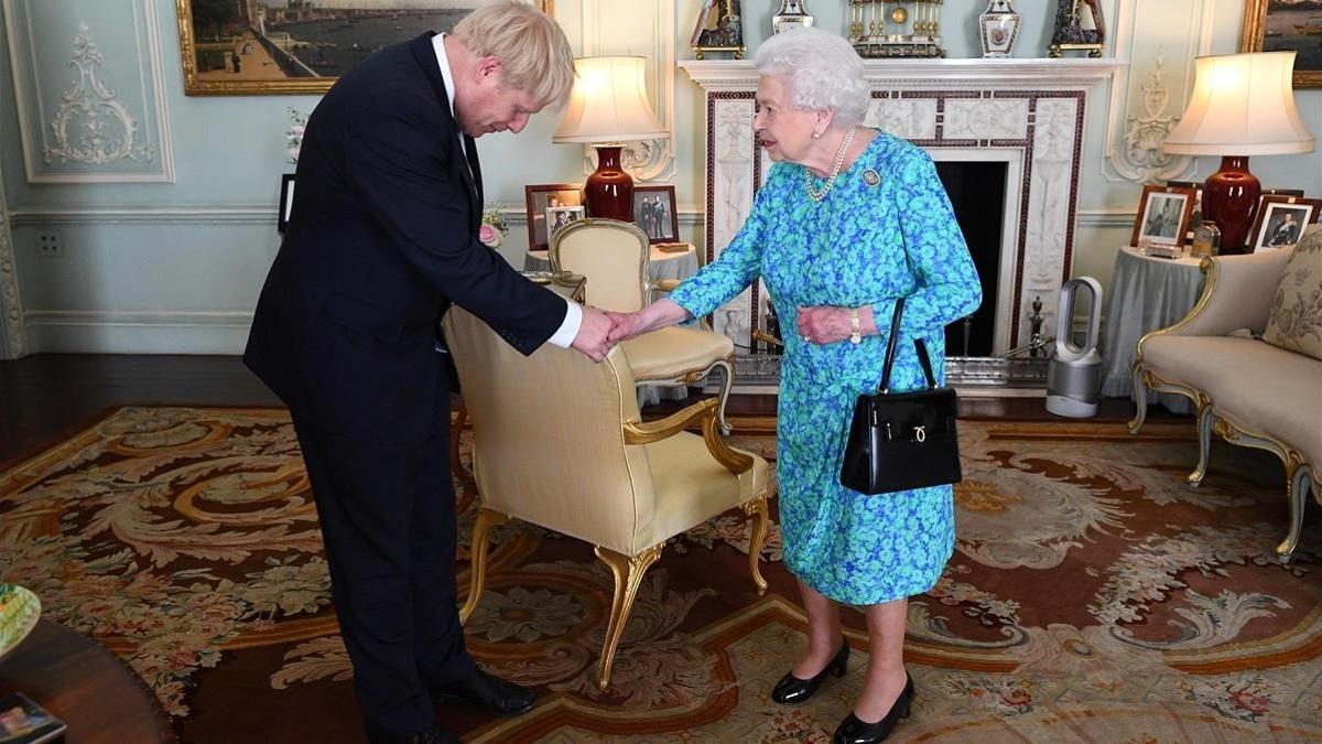 El Primer Ministro Británico Boris Johnson saluda a la Reina Elizabeth II.