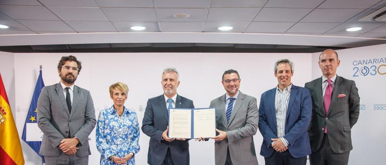 En el centro, Ángel Víctor Torres (i) y Miguel Ángel Domínguez (d) sujetan el convenio firmado en la mañana de lunes.