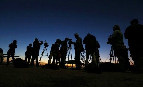 International TV crews await the arrival of a Royal Australian Air Force P-3C Orion aircraft after sunset at RAAF Base Pearce near Perth