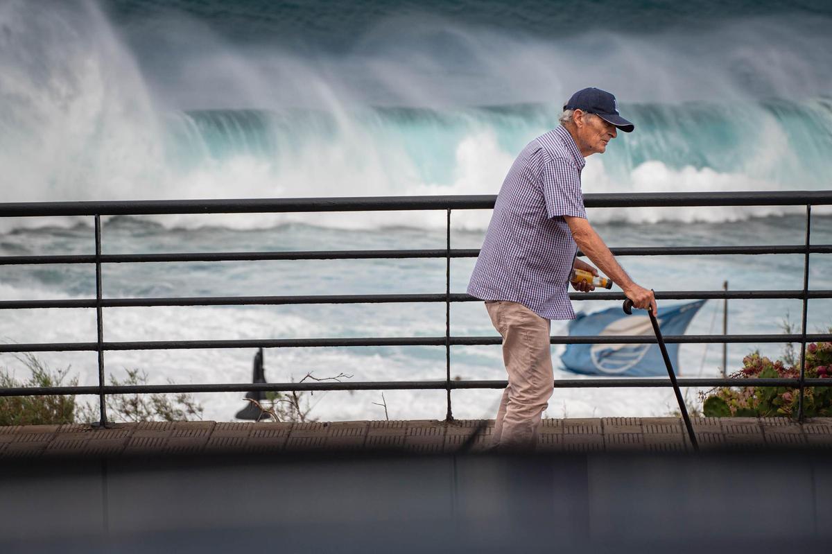 Un hombre con el fuerte oleaje de fondo