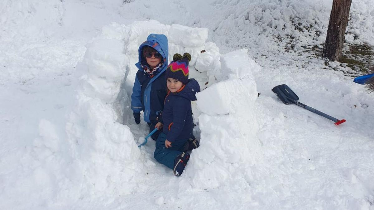 Dos niños construyendo un iglú en Sabiñánigo, tras las nevadas recibidas en los últimos días en la localidad.