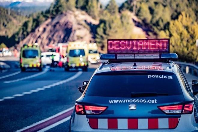 Un coche de los Mossos dEsquadra y una ambulancia del SEM en un accidente en la carretera.