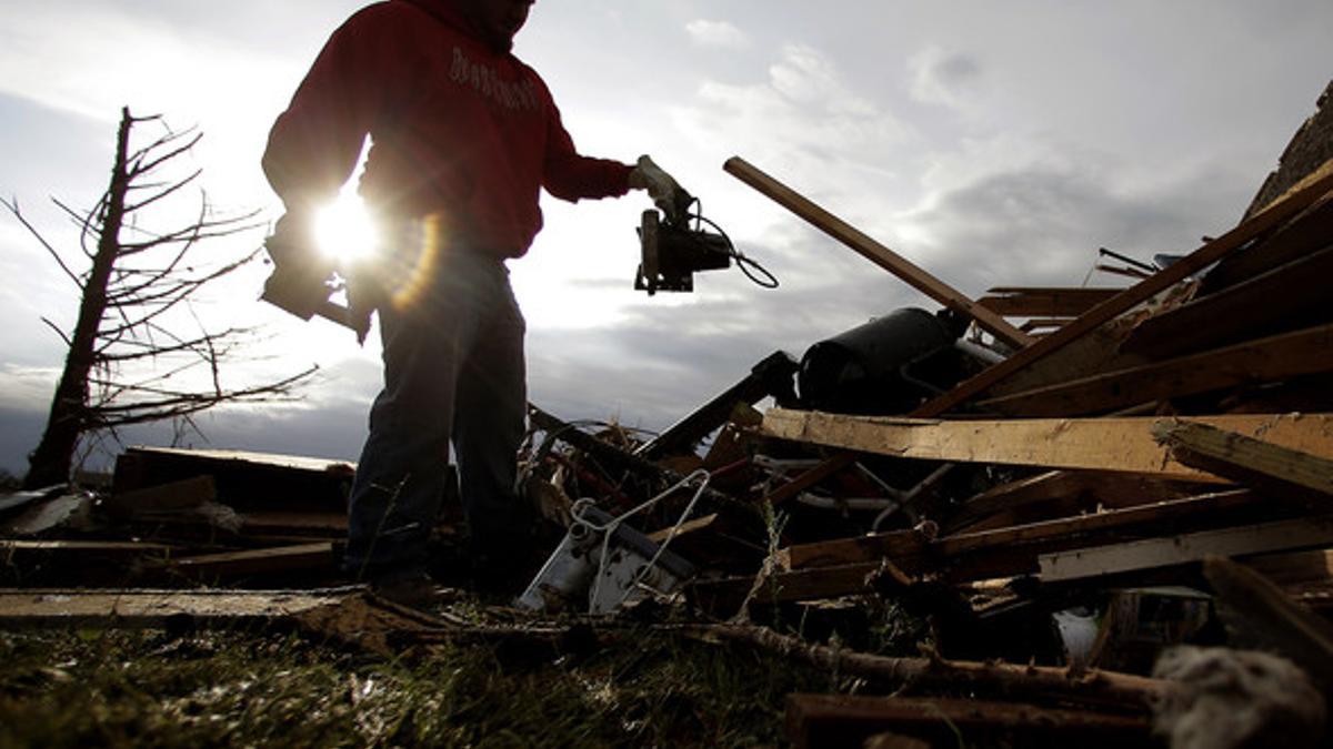 Un hombre rebusca entre los escombros de su casa para ver si hay algún objeto que se pueda salvar de entre las ruinas, este martes.