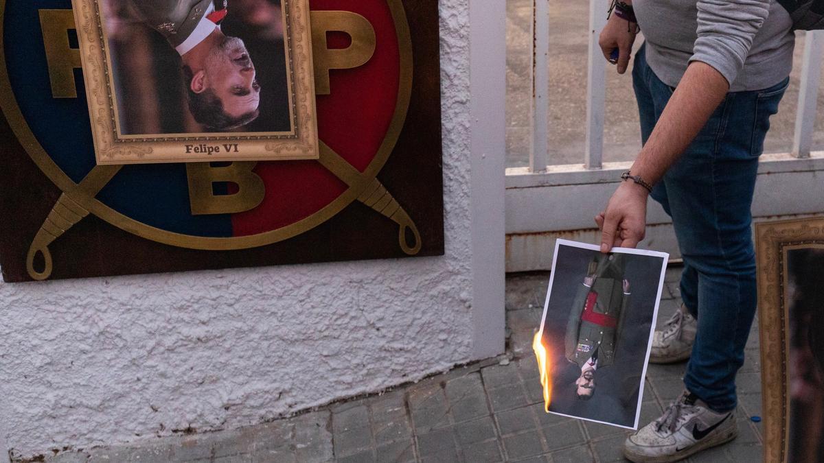 Un manifestante quema un retrato del Felipe VI.