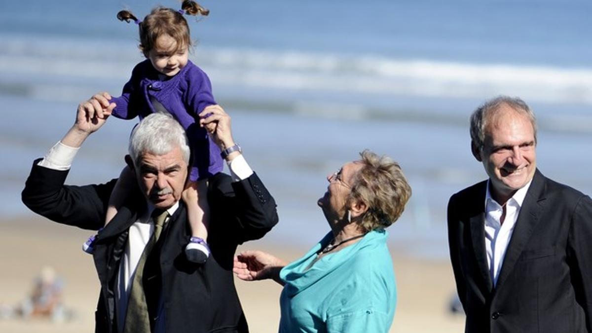 Maragall sostiene a su nieta Maya ante la mirada de su esposa, Diana Garrigosa, y del director de 'Bicicleta, cullera, poma', Carlos Bosch, hoy, en San Sebastián.