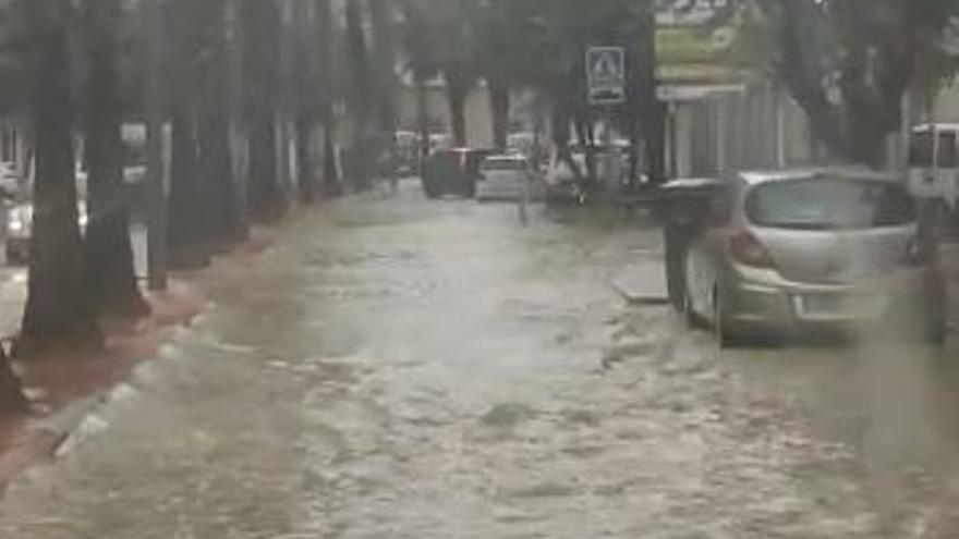 La avenida Juan Carlos I de Sax anegada por la tormenta de la tarde de este jueves.