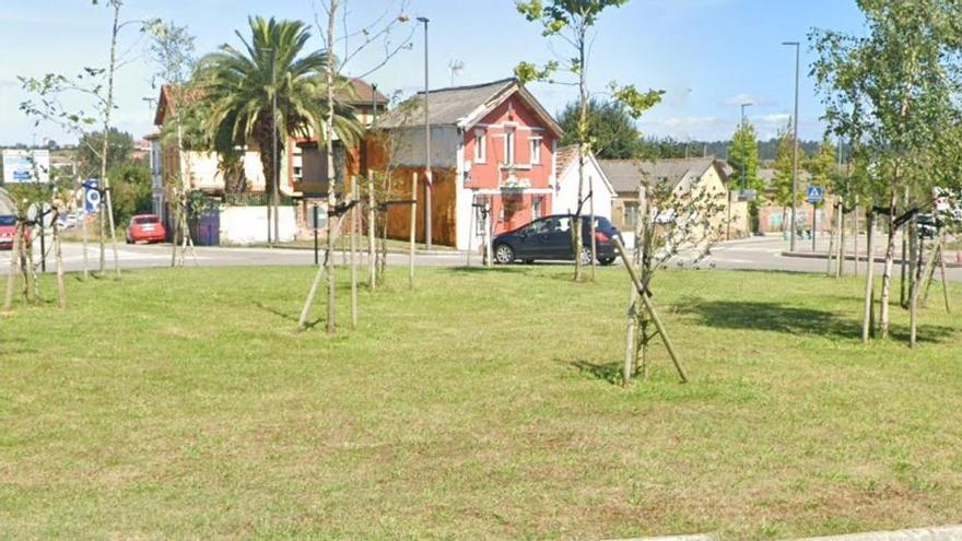 Rotonda de El Castro, en Lugones, con algunos de los inmuebles que serán expropiados al fondo.
