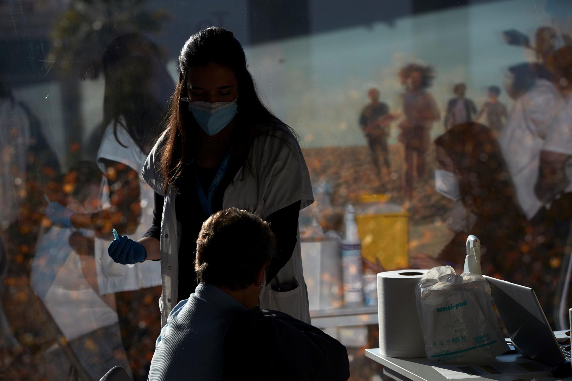 Una profesional sanitaria vacuna a una mujer en la sede de Casa Seat en Barcelona.