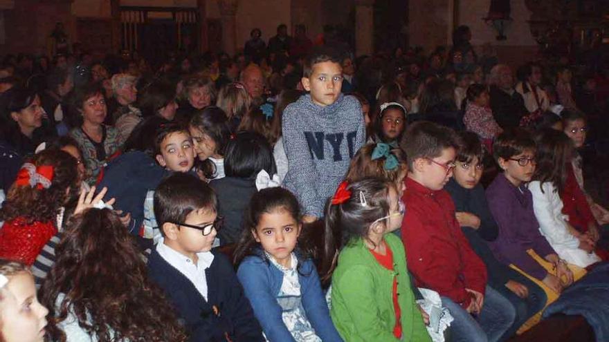 Alumnos de uno de los colegios participantes esperan su turno, mientras entona su villancico la Escuela de Música. Fotos