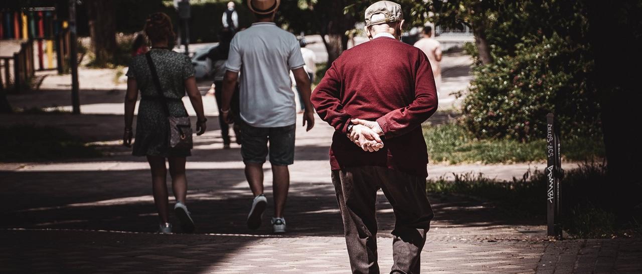 Un hombre mayor pasea por la calle.