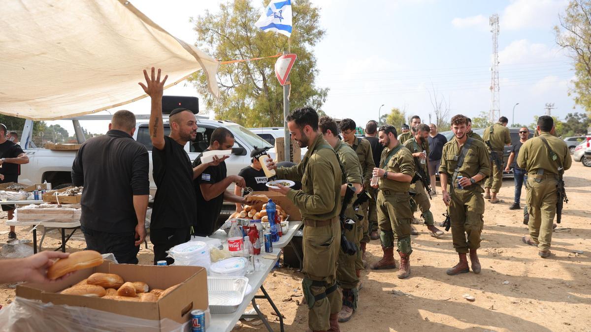 Voluntarios dan comida a los militares israelís.