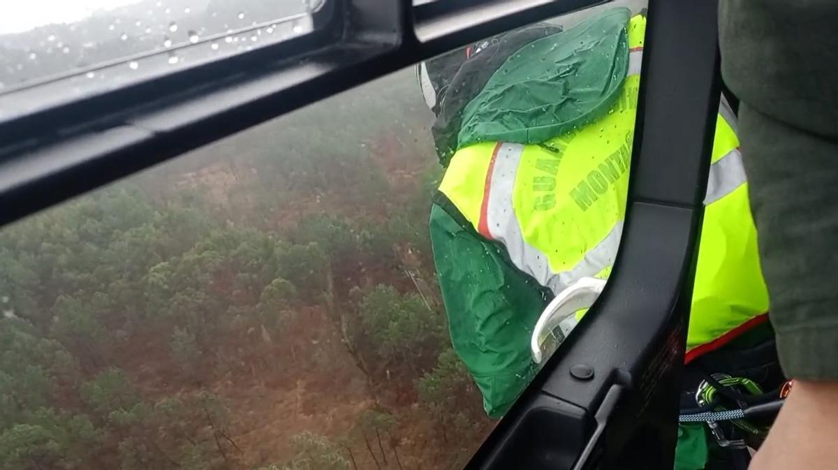 Agentes del GREIM buscan al octogenario desde un helicóptero, pese a la lluvia.