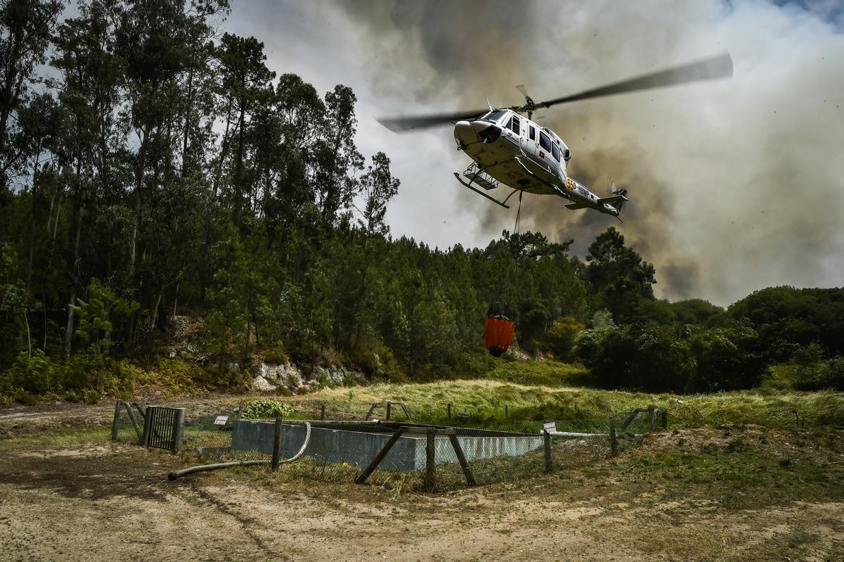 - Un helicóptero se llena de agua en un tanque de riego durante el incendio forestal en el pueblo de Lavradio, Ourem, Portugal, el 13 de julio de 2022. Dieciséis de los 18 distritos de Portugal continental están bajo aviso rojo, el más grave, debido al calor , con más de un centenar de comarcas en peligro máximo de incendio rural. (Incendio) EFE/EPA/NUNO ANDRE FERREIRA