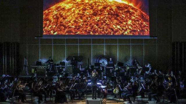 Un momento del concierto de Oviedo Filarmonía en el Auditorio, bajo las imágenes proyectadas.