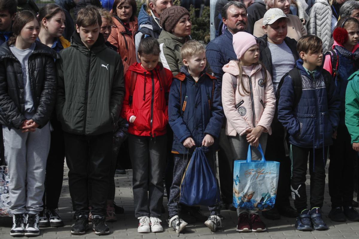 Los niños asisten a una reunión dedicada a la reapertura de su escuela número uno, en Volnovakha, Ucrania
