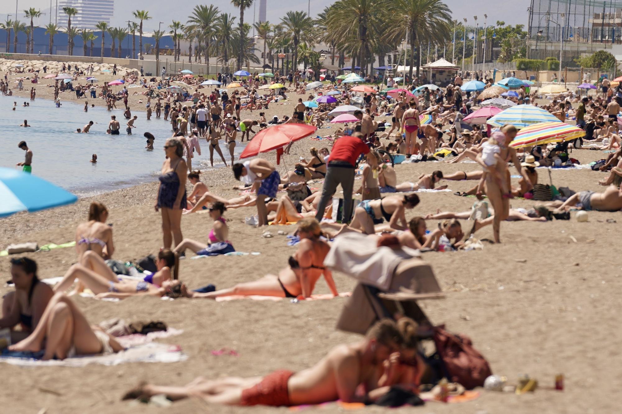 Bañistas y turistas disfrutan del sol y el calor en la playa de La Malagueta a mediados de abril.
