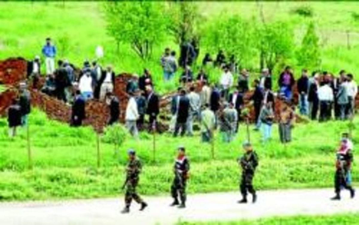 Habitants de Bilge, al costat de les tombes cavades per sepultar les víctimes de la massacre, ahir. Habitants de Bilge, al costat de les tombes cavades per sepultar les víctimes de la massacre, ahir.