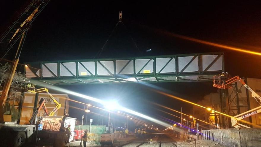 Momento en el que los operarios colocan la pasarela de Santiago El Mayor sobre las vías.