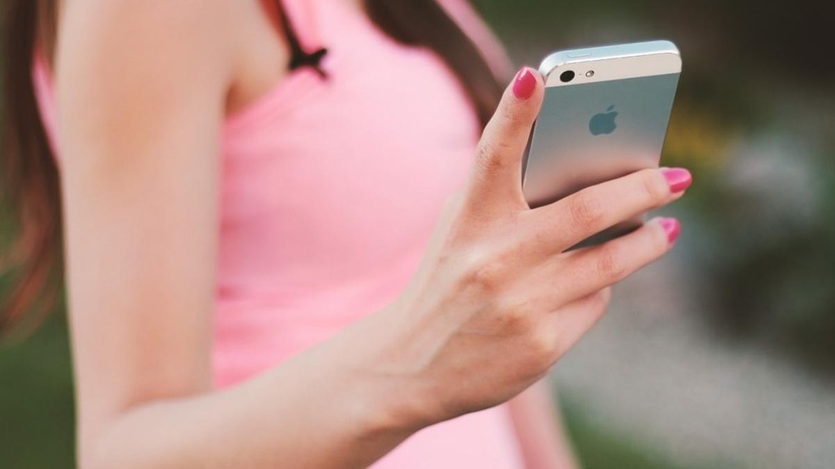 Una chica sostiene un teléfono iPhone